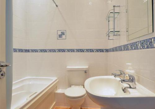 ein Badezimmer mit einem Waschbecken, einer Badewanne und einem WC in der Unterkunft Rame Lemain Garden Apts in Looe