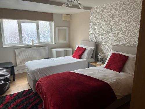 Habitación de hotel con 2 camas con almohadas rojas en Swindon Home from Home 2 - EnterCloud9SA, en Swindon