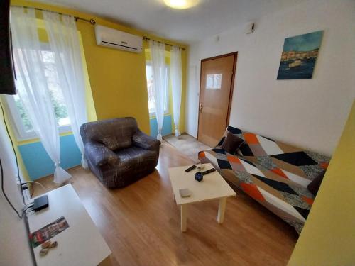 a living room with a couch and a chair at Apartmani Jadran in Mali Lošinj