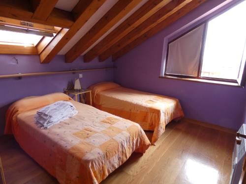 een kamer met 2 bedden en een raam bij Alojamiento Turístico Prellezo in Prellezo