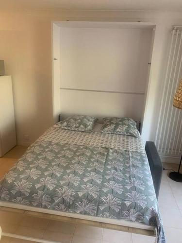 une chambre avec un lit avec une couette bleue dans l'établissement Joli Studio avec piscine, à Mandelieu-la-Napoule