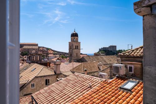 einen Blick auf die Dächer einer Stadt mit einem Uhrturm in der Unterkunft Old Town Duodecim in Dubrovnik