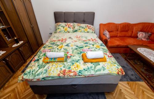1 dormitorio con 1 cama con colcha de flores en Studio apartman Ivana, en Gradište