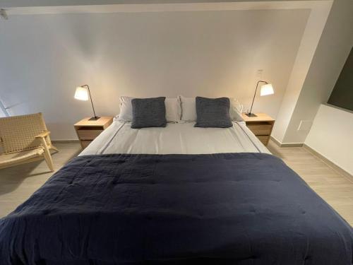a large bed in a room with two lamps at HOM I Espectacular Loft conEstacionamiento en Valparaíso in Valparaíso