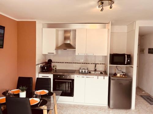 a kitchen with white cabinets and a table with chairs at Apartament al centre ideal parelles a Platja d'Aro in Platja  d'Aro