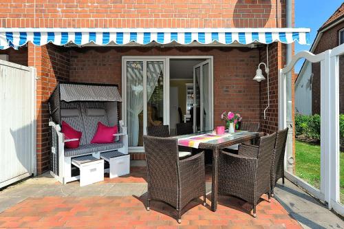 d'une terrasse avec une table et des chaises dans une maison en briques. dans l'établissement Ferienhaus Strandidylle, à Carolinensiel