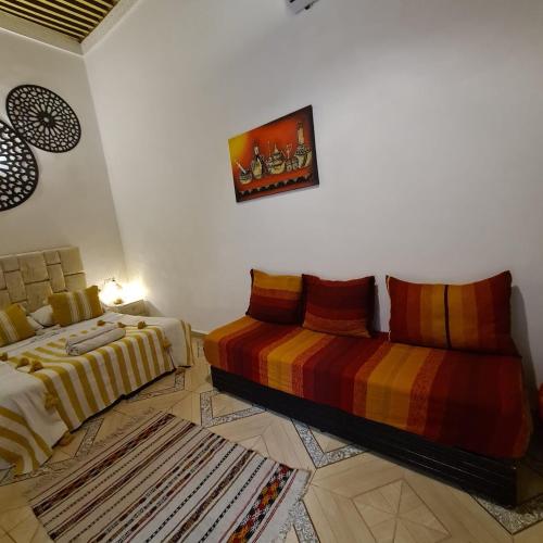 a bedroom with two beds and a rug at Riad bel kayed in Fès