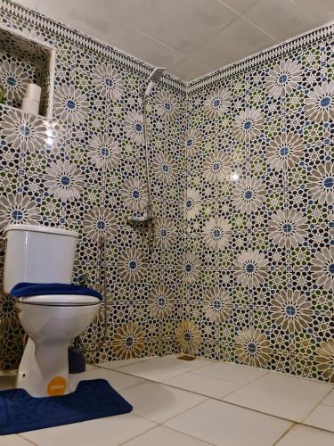 a bathroom with a toilet and a tile wall at Riad bel kayed in Fès