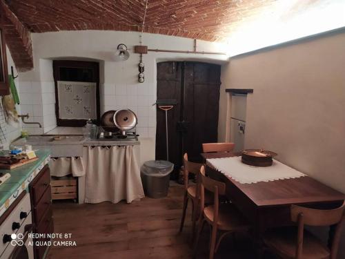 eine Küche mit einem Tisch und Stühlen im Zimmer in der Unterkunft Da Meme' in Paesana