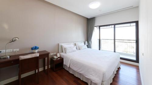 une chambre avec un lit blanc et une grande fenêtre dans l'établissement Citiresort Living sukhumvit 39, à Makkasan