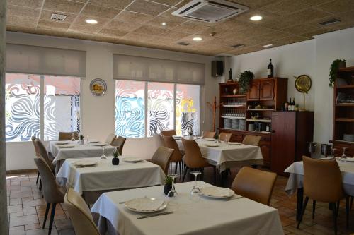 a restaurant with white tables and chairs and windows at Gran Hotel Toledo in Onda