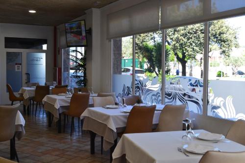 a restaurant with white tables and chairs and windows at Gran Hotel Toledo in Onda
