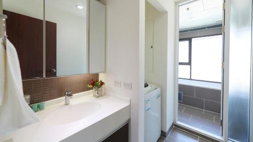 une salle de bain avec un lavabo et un miroir dans l'établissement Citiresort Living sukhumvit 39, à Makkasan