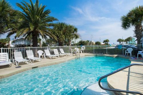 a large swimming pool with chairs and palm trees at Seahorse 612 in Gulf Shores