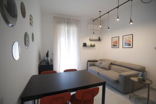 a living room with a couch and a table and chairs at Pausa Mare Seaside in Torre a Mare