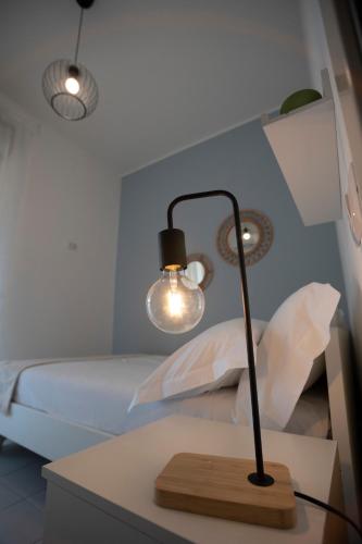 a lamp on a table next to a bed at Pausa Mare Seaside in Torre a Mare