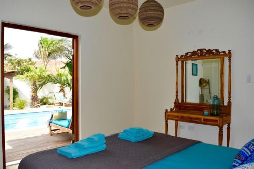 1 dormitorio con espejo, 1 cama y piscina en Endless Summer, en Palm-Eagle Beach