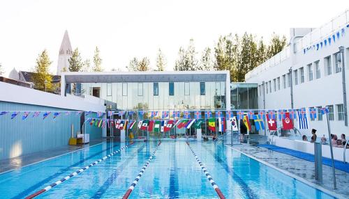 een zwembad met vlaggen aan de zijkant van een gebouw bij Fox Hotel in Reykjavík