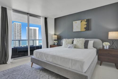 a bedroom with a large bed and a large window at Stunning Beach Resort Large 4BR 3BA Condo 24 FL in Hallandale Beach
