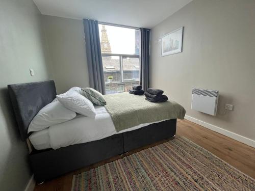 a bedroom with a bed with a window and a rug at Pettit Apartments - Central "Free Parking" in Liverpool