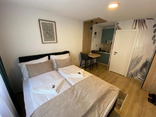 ein kleines Schlafzimmer mit einem Bett und einer Küche in der Unterkunft Apartments HAN 2 Sarajevo in Sarajevo