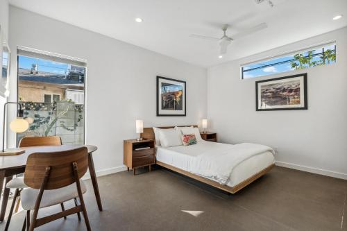 a bedroom with a bed and a desk and a window at 4 Square Studios in Phoenix