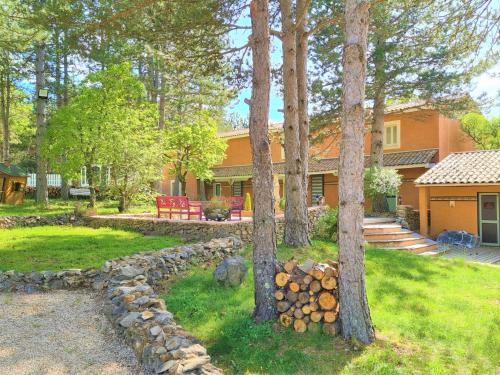 een huis met bomen en een stenen muur bij Domaine du Val de Sault in Sault-de-Vaucluse