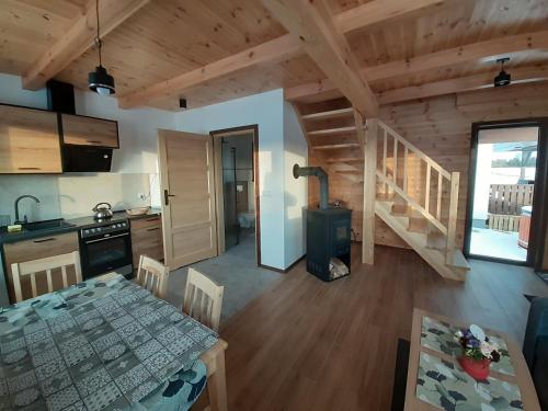 a kitchen and a dining room with a table in a cabin at Agroturystyka '' U Adasia i Marysi '' - Domek nad jeziorem in Dębogóry