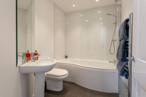 a bathroom with a sink and a toilet and a bath tub at King’s Road Apartments in Harrogate