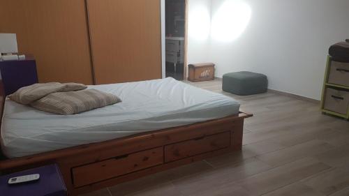 1 cama con marco de madera en una habitación en Casa corti, en Corte