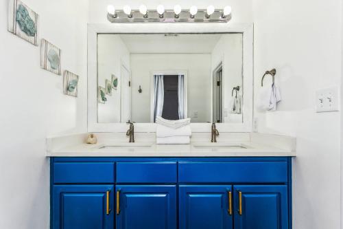 La salle de bains est pourvue de placards bleus et d'un grand miroir. dans l'établissement 1634 Bulevar Menor, à Pensacola Beach