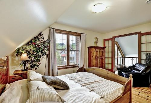 a bedroom with a bed and a chair and a window at 9020 Chemin des Alpages in Stoneham