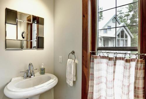 uma casa de banho com um lavatório e uma janela em 9020 Chemin des Alpages em Stoneham