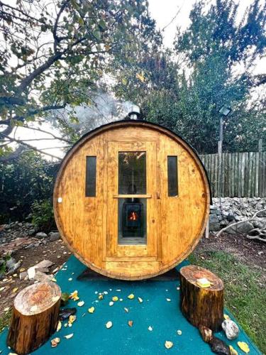 a round wooden house with two logs in a yard at Olmué, cabaña in Granizo