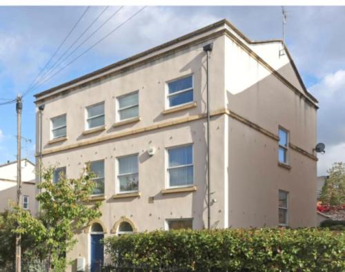 a large white building with windows and a hedge at 5 Bed Modern Cheltenham Town Centre Home in Cheltenham