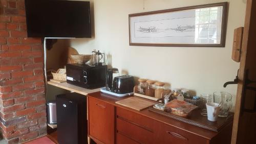 a kitchen with a counter with a coffee maker and a microwave at Billys in Kedington