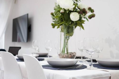 ein weißer Tisch mit einer Vase Blumen drauf in der Unterkunft Newly Renovated Modern 4 Bed 3 Bath Apartment London in London
