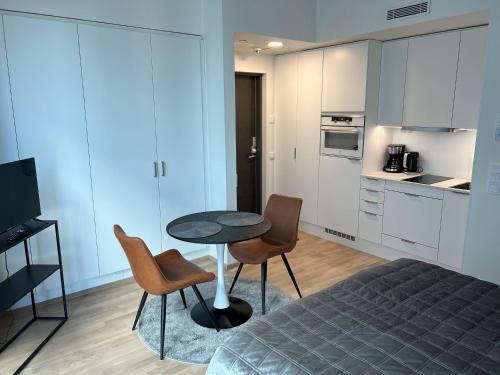 ein Schlafzimmer mit einem Tisch und Stühlen sowie eine Küche in der Unterkunft ARENA Studio 2 in Tampere