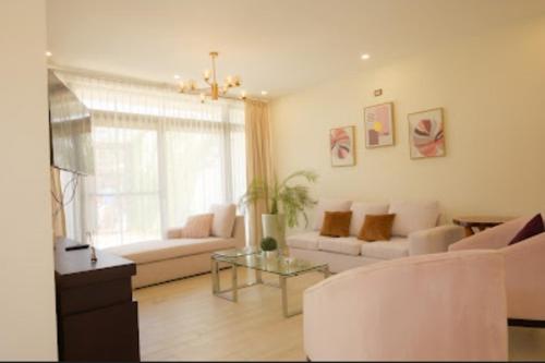 a living room with white furniture and a glass table at Casa Tikal cerca de aeropuerto in Flores