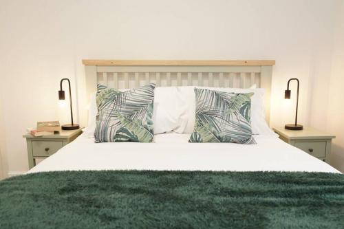 a bedroom with a bed with pillows and two lamps at Newly Renovated Modern 4 Bed 3 Bath Apartment London in London