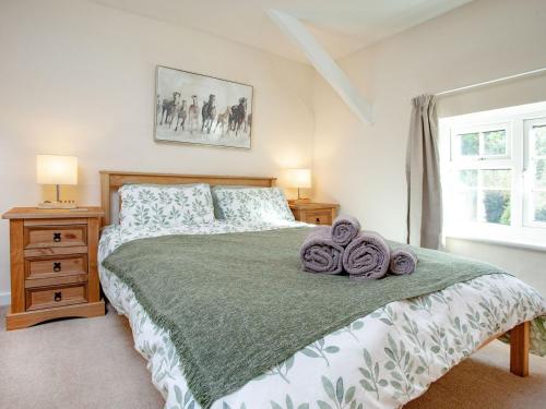 a bedroom with a large bed with towels on it at Otters Cottage in Ottery Saint Mary