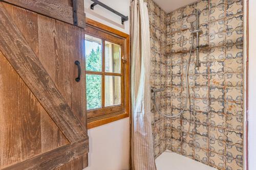 baño con ducha y puerta de madera en Chambre d'hôte La Vinha aux Lesmaisonsdeshoussats, en Trensacq