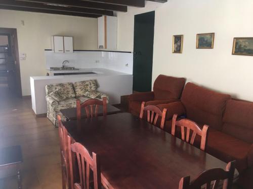 uma sala de estar com uma mesa e um sofá em Cortijo de Lorente Alojamiento Turístico Rural -Teba -Malaga em Teba