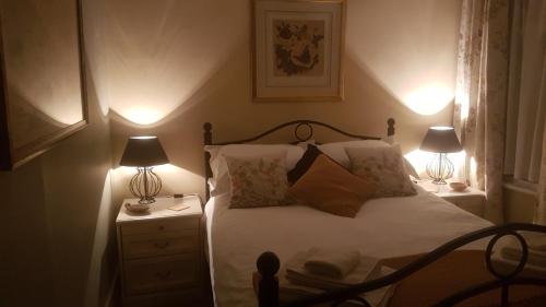 a bedroom with a bed with two lamps on it at Billys in Kedington