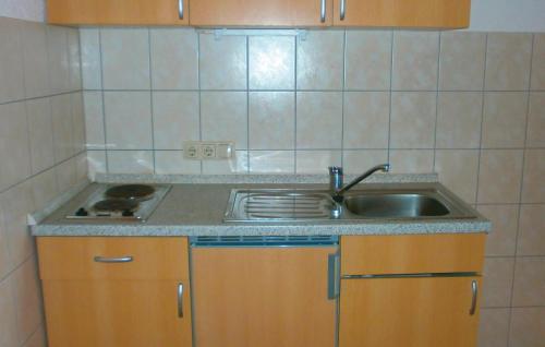 a small kitchen with a sink and a stove at Lovely Apartment In Thulendorf-sagerheide With Kitchenette in Thulendorf