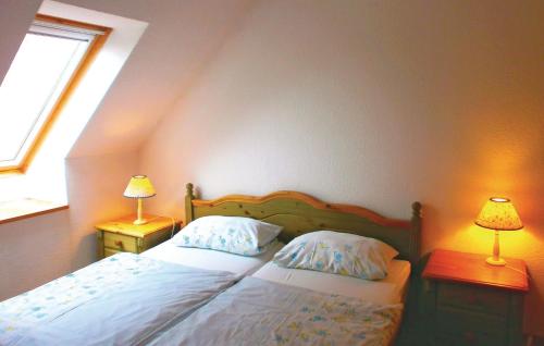 a bedroom with a bed with two lamps on two tables at Lovely Apartment In Thulendorf-sagerheide With Kitchenette in Thulendorf