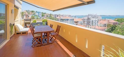 Elle comprend un balcon avec une table et des chaises en bois. dans l'établissement Top Sea View Lisboa - Oeiras, à Paço de Arcos