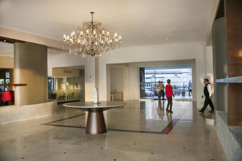 a large lobby with a chandelier and a table in the middle at Hotel Antofagasta in Antofagasta