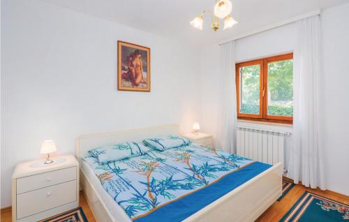 a white bedroom with a bed and a window at 2 Bedroom Lovely Apartment In Labin in Labin