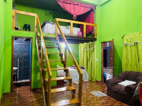 Habitación con una pared verde y literas. en Mario Algarin en Puerto Iguazú
